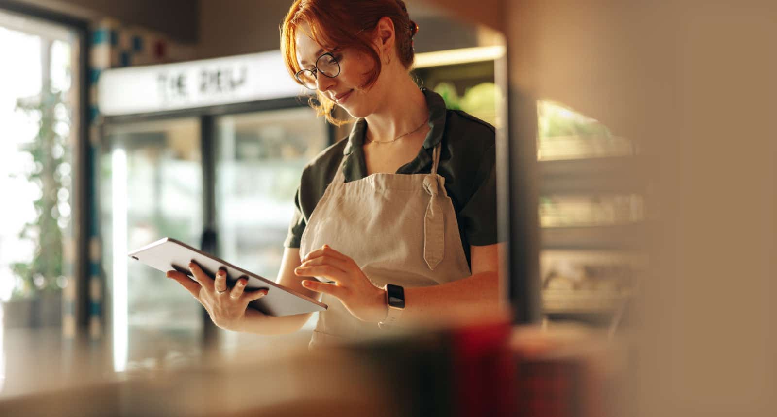 Business owner on tablet in a cafe